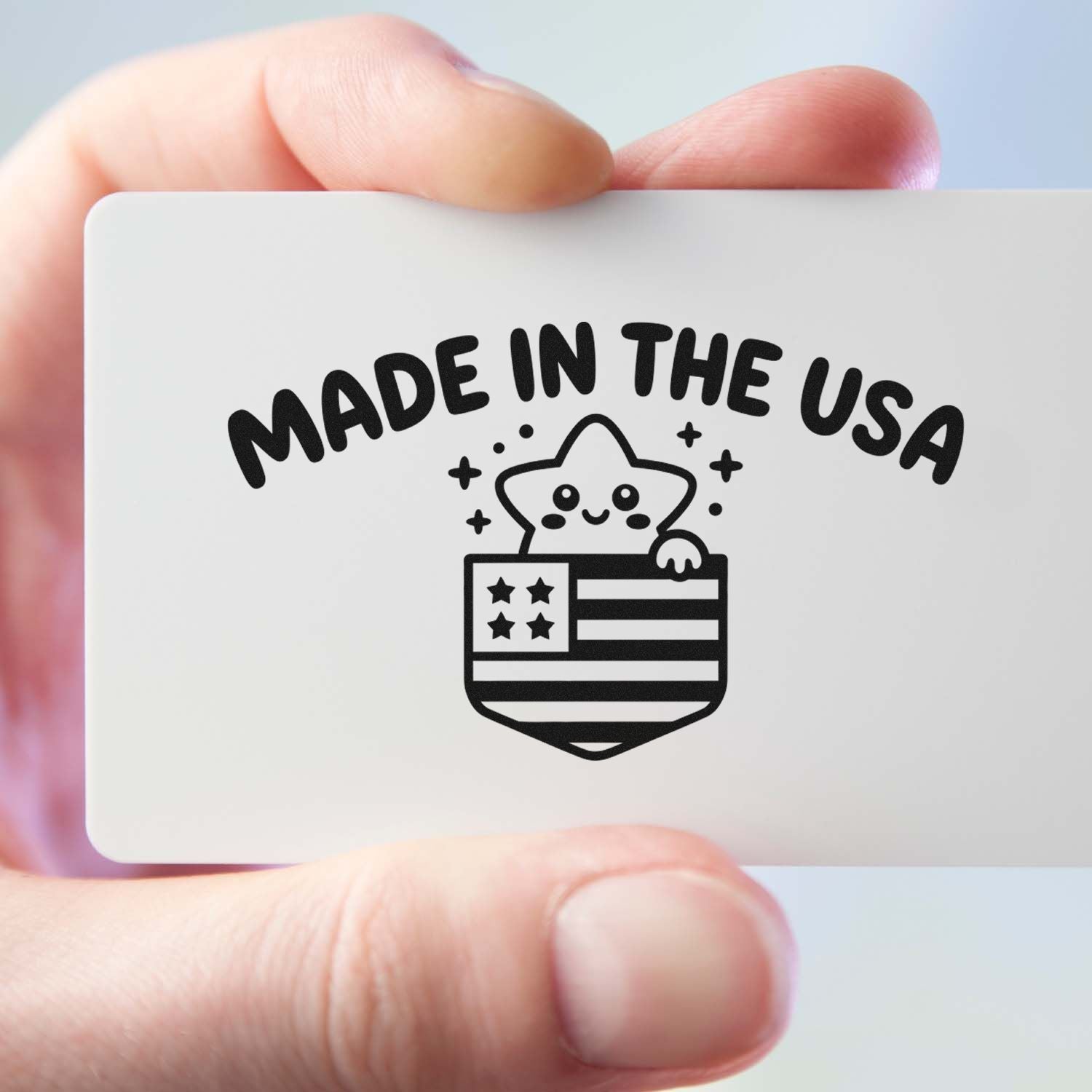 White stamp seal with black Made in the USA text and smiling star over an American flag, held in hand.