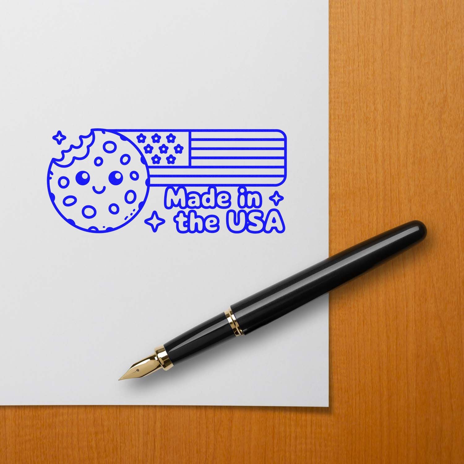 Blue Made in the USA stamp seal with smiling cookie, stars, and flag stripes beside a black fountain pen.