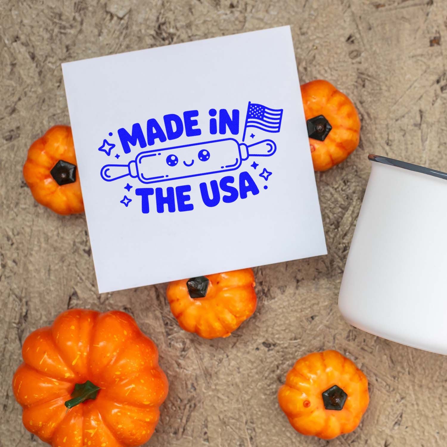 Blue Made in the USA stamp and seal design on white paper, with orange pumpkins and a white stamp handle.