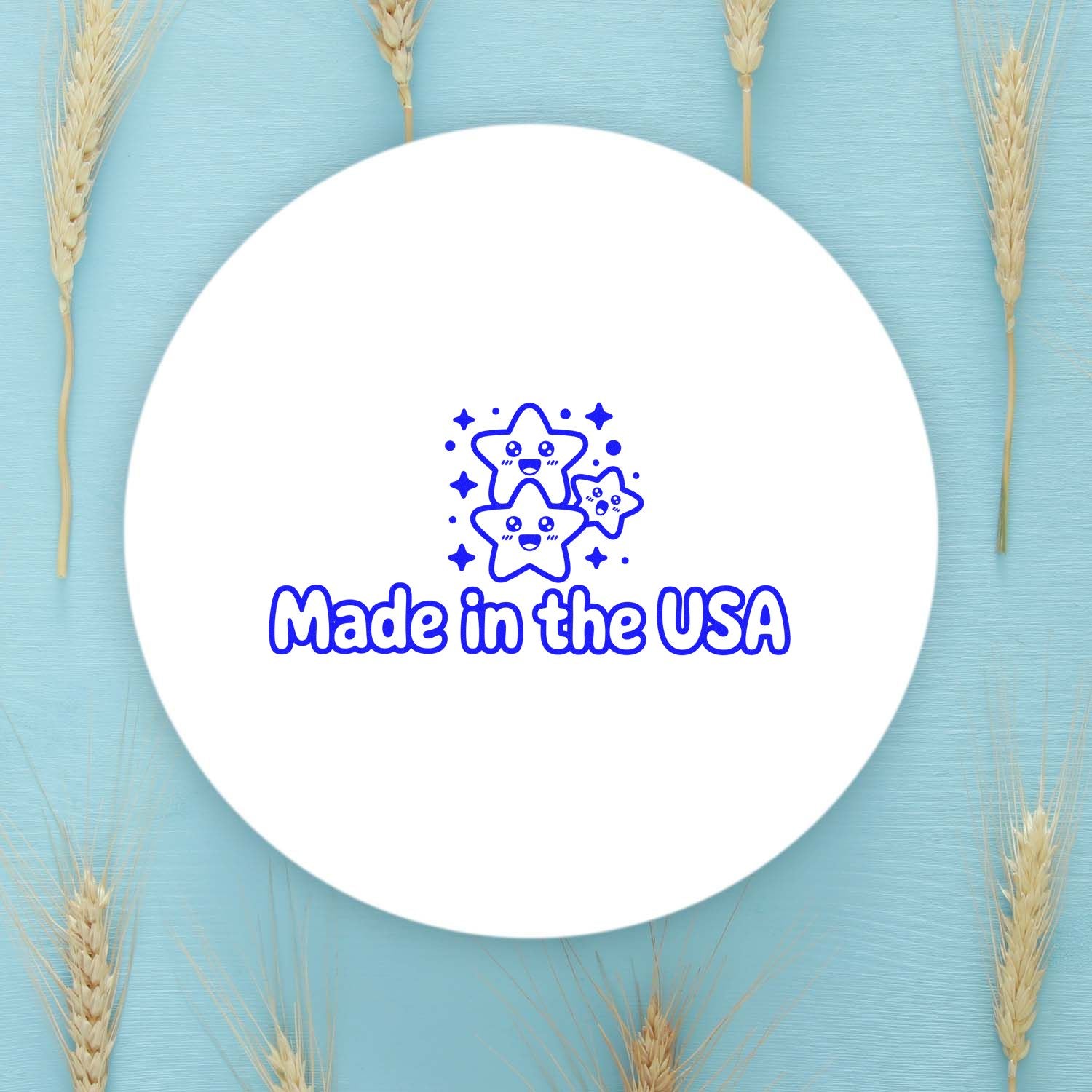 Round white stamp seal with blue Made in the USA text and smiling stars on a light blue background with wheat stalks.