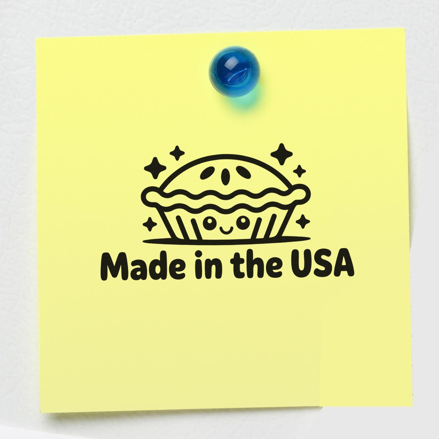 Yellow sticky note with blue pushpin and black Made in the USA pie stamp seal.
