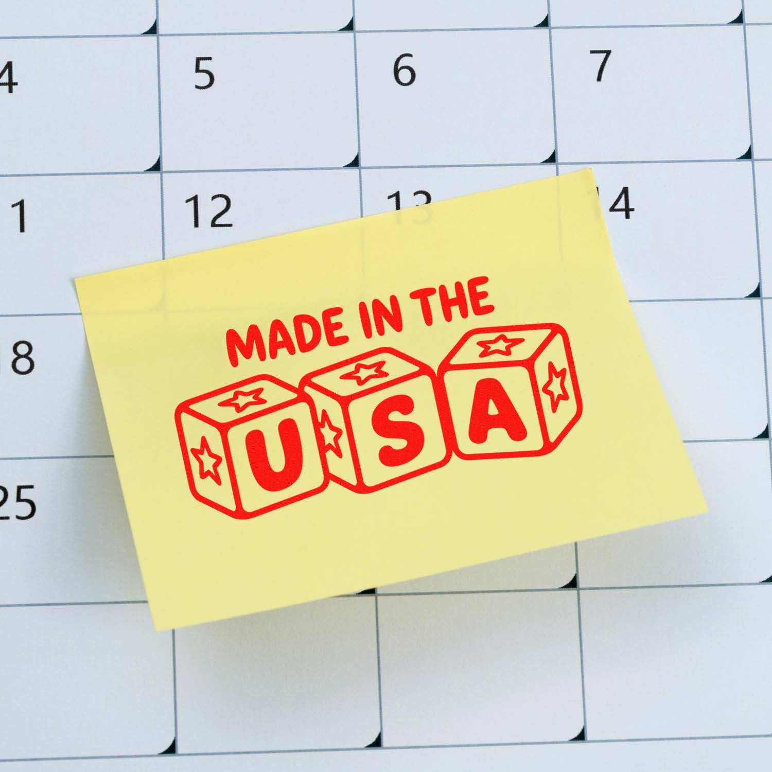 Yellow sticky note with red Made in the USA stamp seal over a calendar grid
