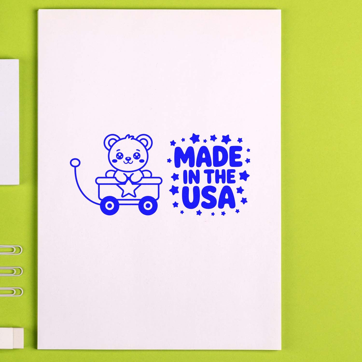 Blue Made in the USA stamp and seal with bear in wagon on white card, set against a lime green background.