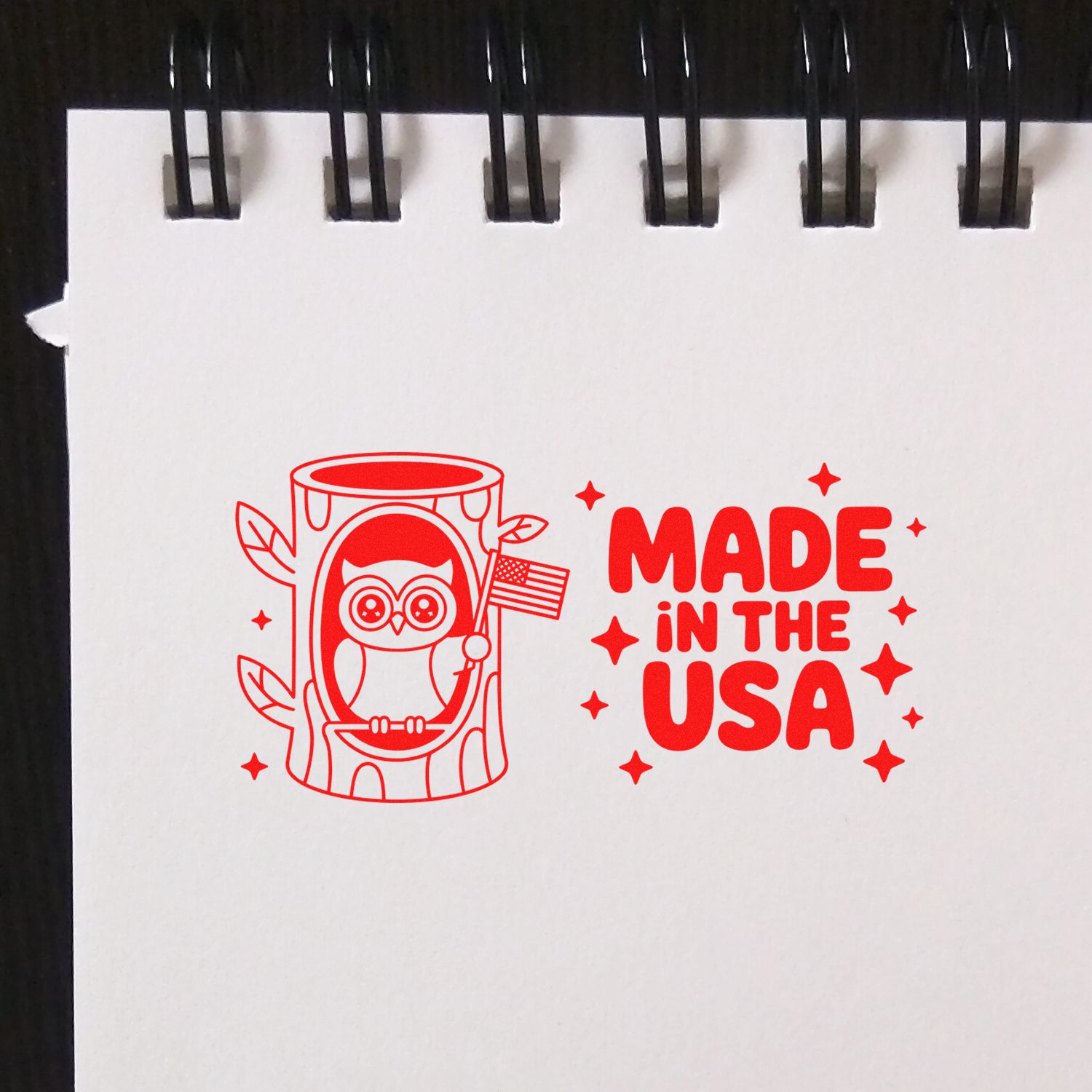 Red stamp-and-seal design with owl in log holding U.S. flag and bold MADE IN THE USA text.