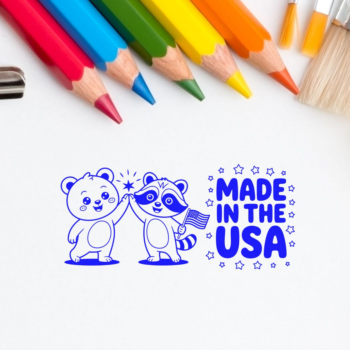 Blue Made in the USA stamp and seal with cartoon bear and raccoon high-fiving, stars, and colored pencils above.