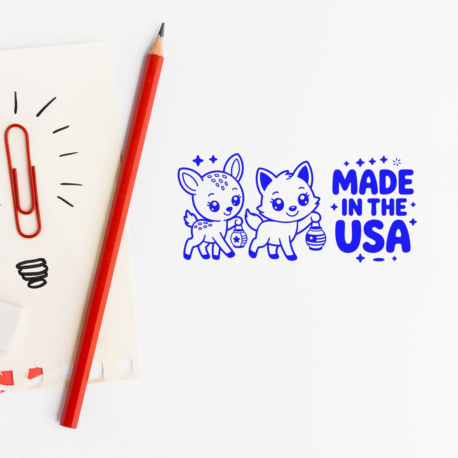 Blue Made in the USA stamp and seal with cute deer and fox, white background, red pencil and paper clip.