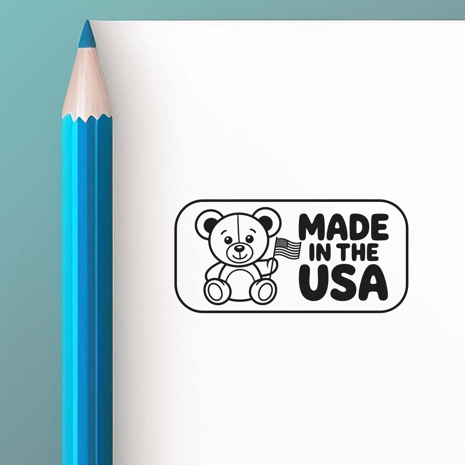 Black Made in the USA bear stamp seal on white paper beside a blue pencil.