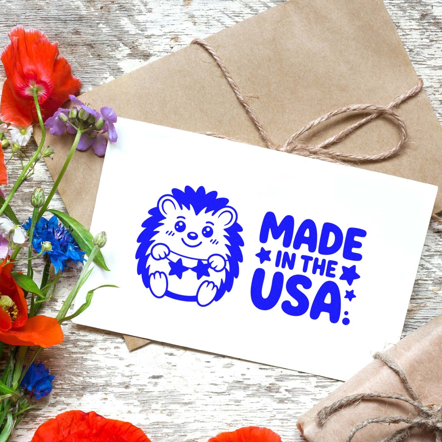 Blue Made in the USA hedgehog stamp and seal on white card, with kraft paper twine wrap and colorful flowers.