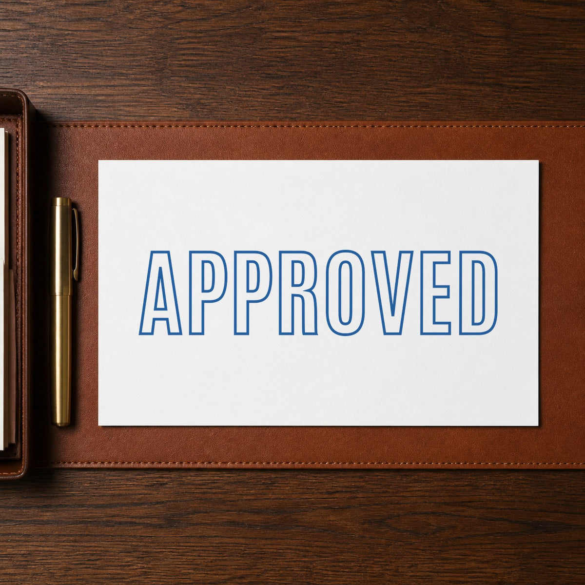 Pre-inked "Approved" stamp marking paperwork in an office setting