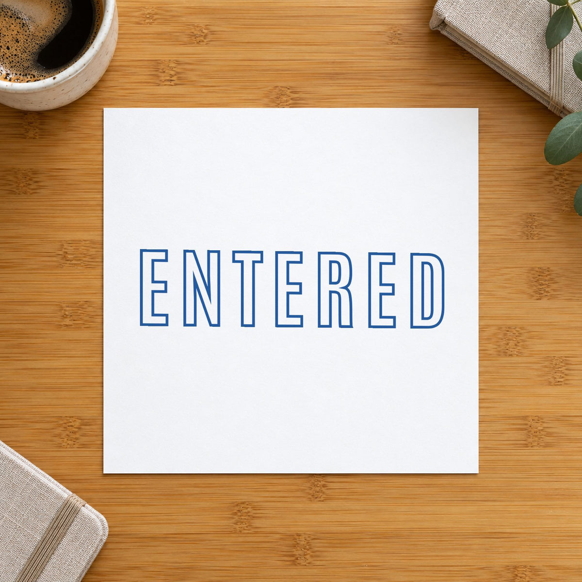 "Entered" Xstamper No. 1021 stamp shown in everyday handling