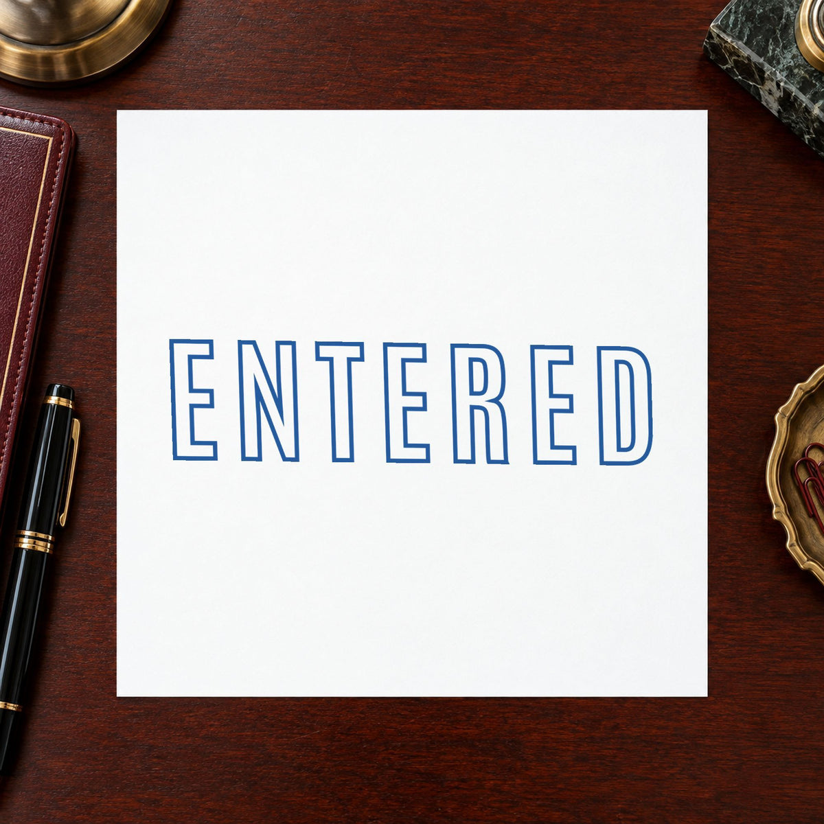 "Entered" Xstamper pre-inked stamp beside its rectangle imprint