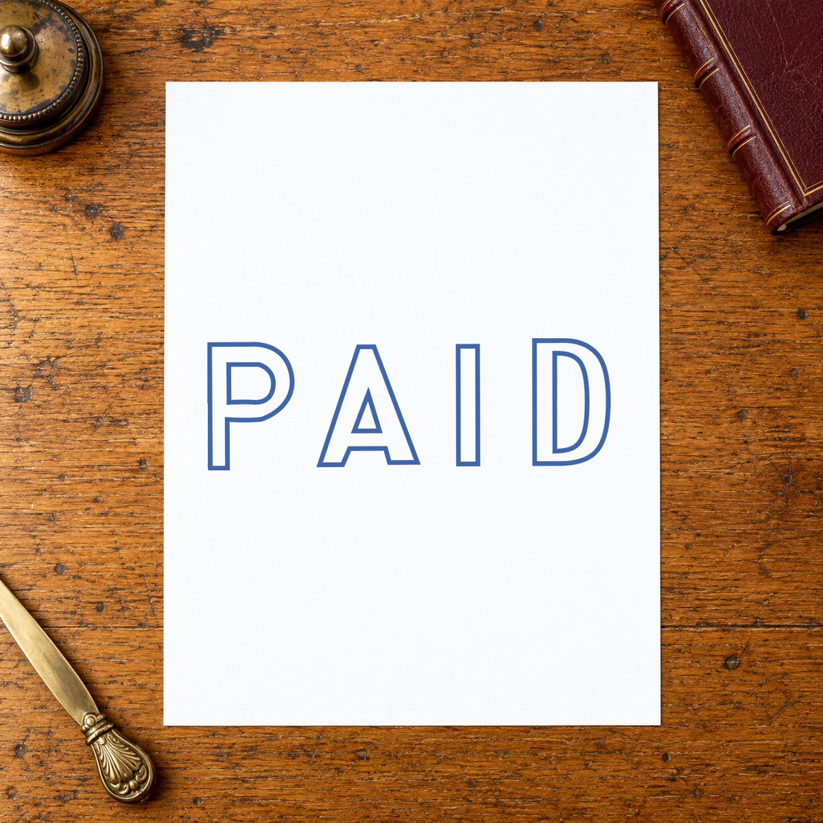 Pre-inked "Paid" stamp applied to a document, Approximately 1/2 in tall x 1-5/8 in wide impression
