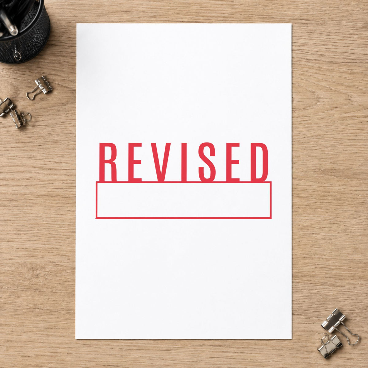 "Revised" Xstamper stamp in use on paper, 1/2 x 1-5/8 in rectangle imprint