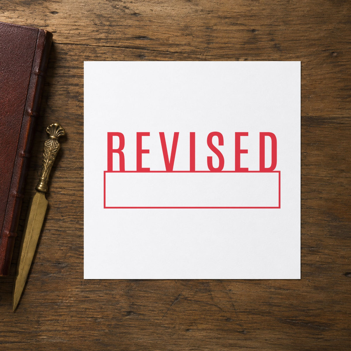"Revised" Xstamper pre-inked stamp beside its rectangle imprint