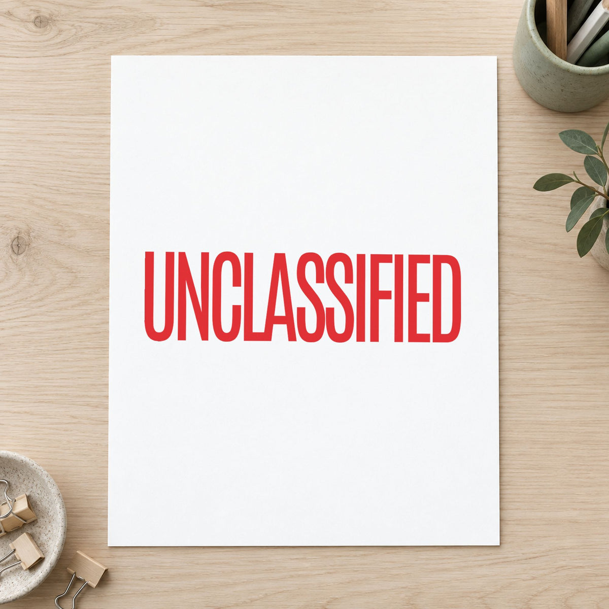 "Unclassified" Xstamper stamp in use on paper, Approximately 1/2 in tall x 1-5/8 in wide rectangle imprint