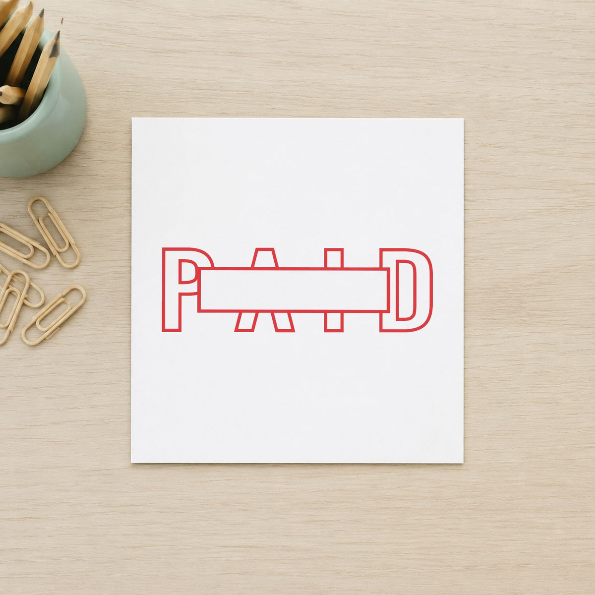 "Paid" Xstamper stamp in use on paper, Approximately 7/8 in tall x 2-3/4 in wide rectangle imprint