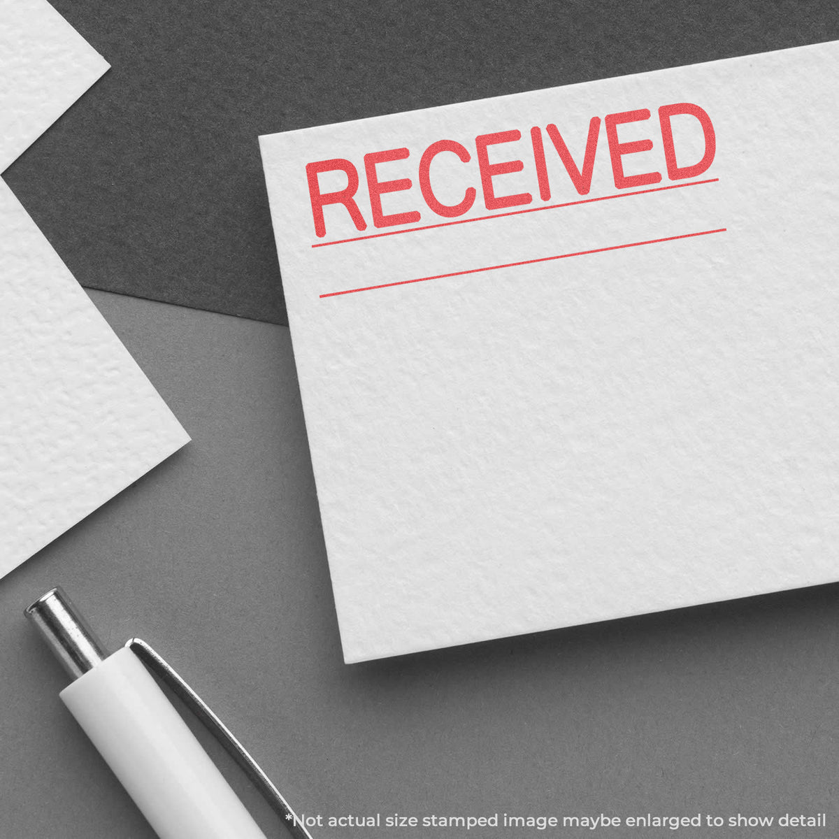 "Received" pre-inked imprint on a page, rectangle shape at Approximately 7/8 in tall x 2-3/4 in wide