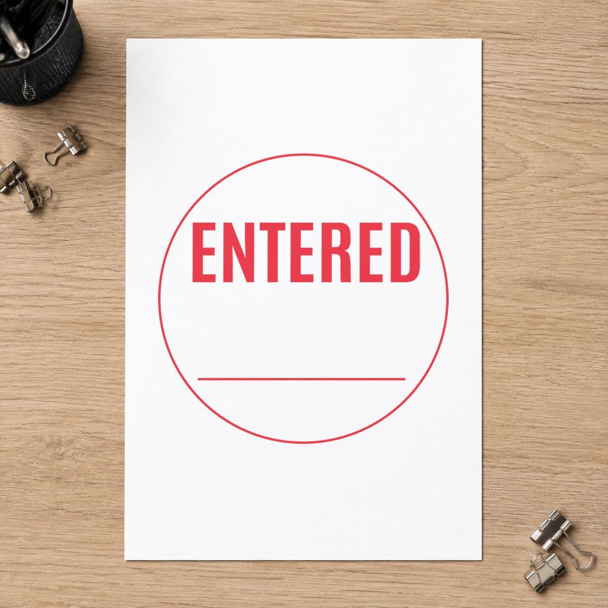 "Entered" Xstamper stamp in use on paper, Approximately 5/8 in diameter round imprint