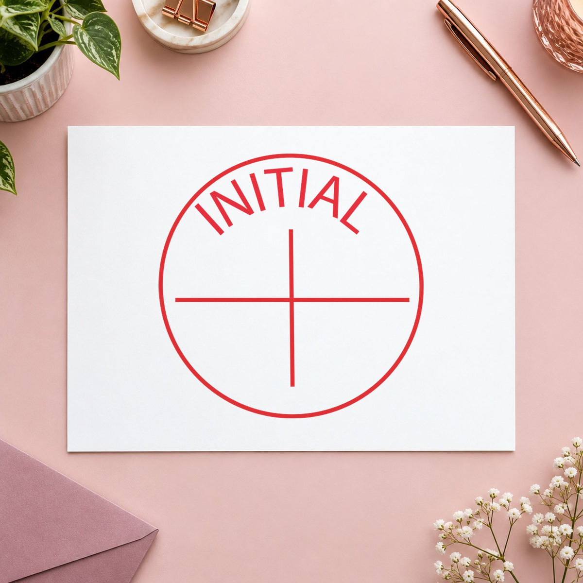 "Initial" Xstamper stamp in use on paper, 5/8 in diameter round imprint