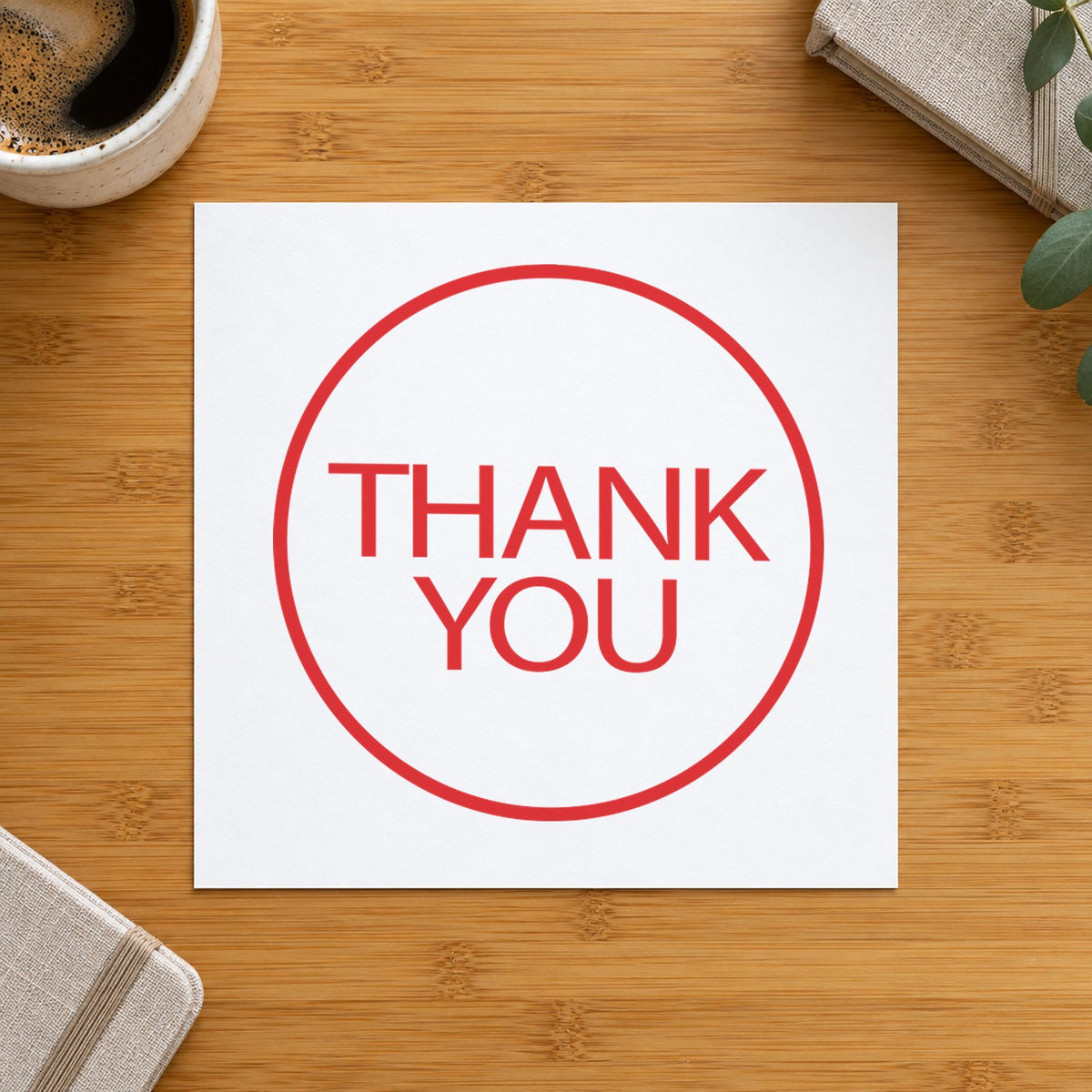 "Thank you" Xstamper stamp in use on paper, Approximately 5/8 in diameter round imprint