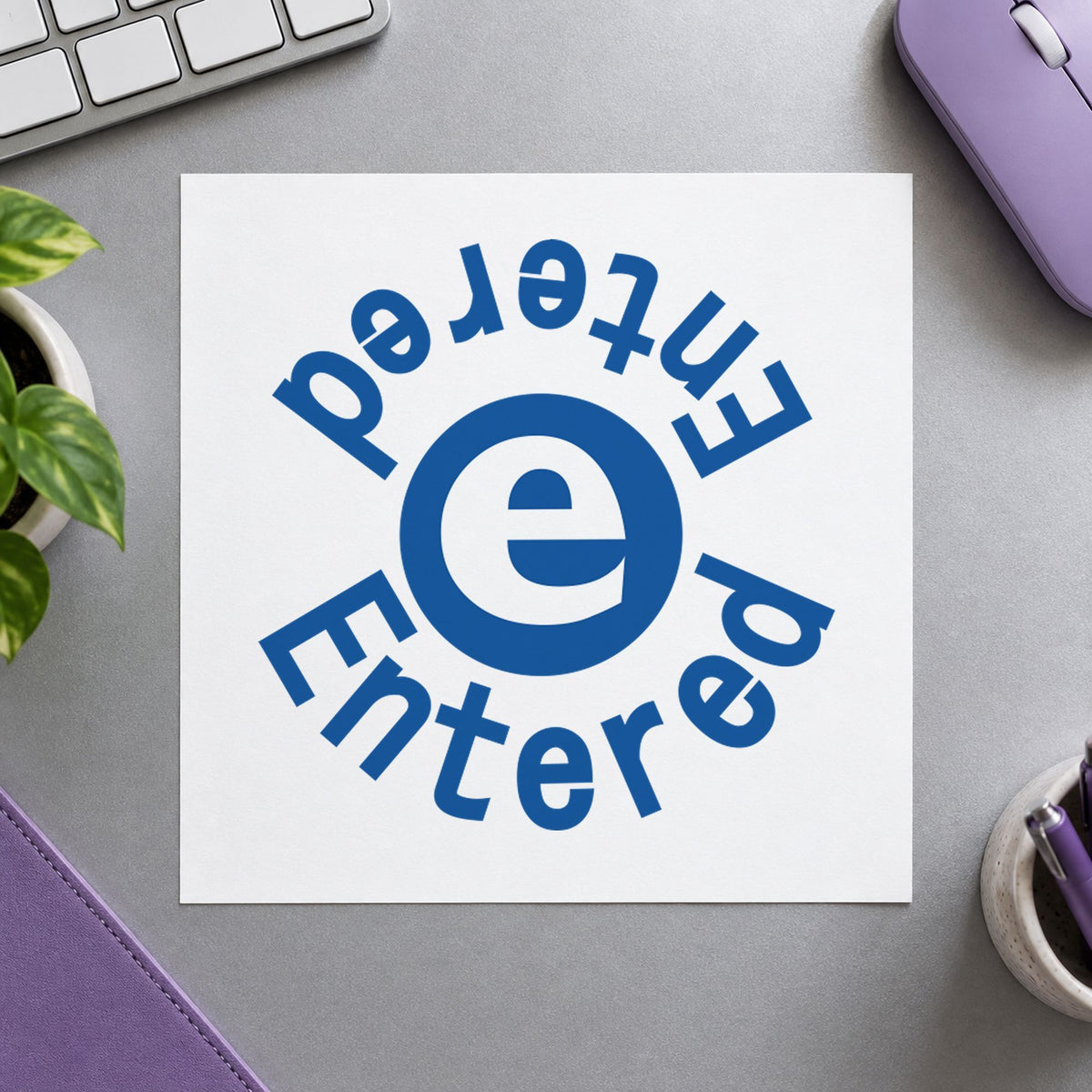 "Entered" Xstamper stamp in use on paper, Approximately 5/8 in diameter round imprint