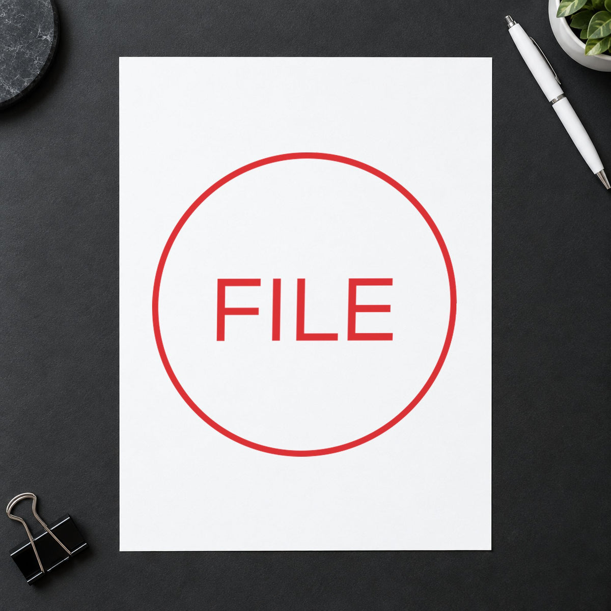 "File" Xstamper stamp in use on paper, 5/8 in diameter round imprint