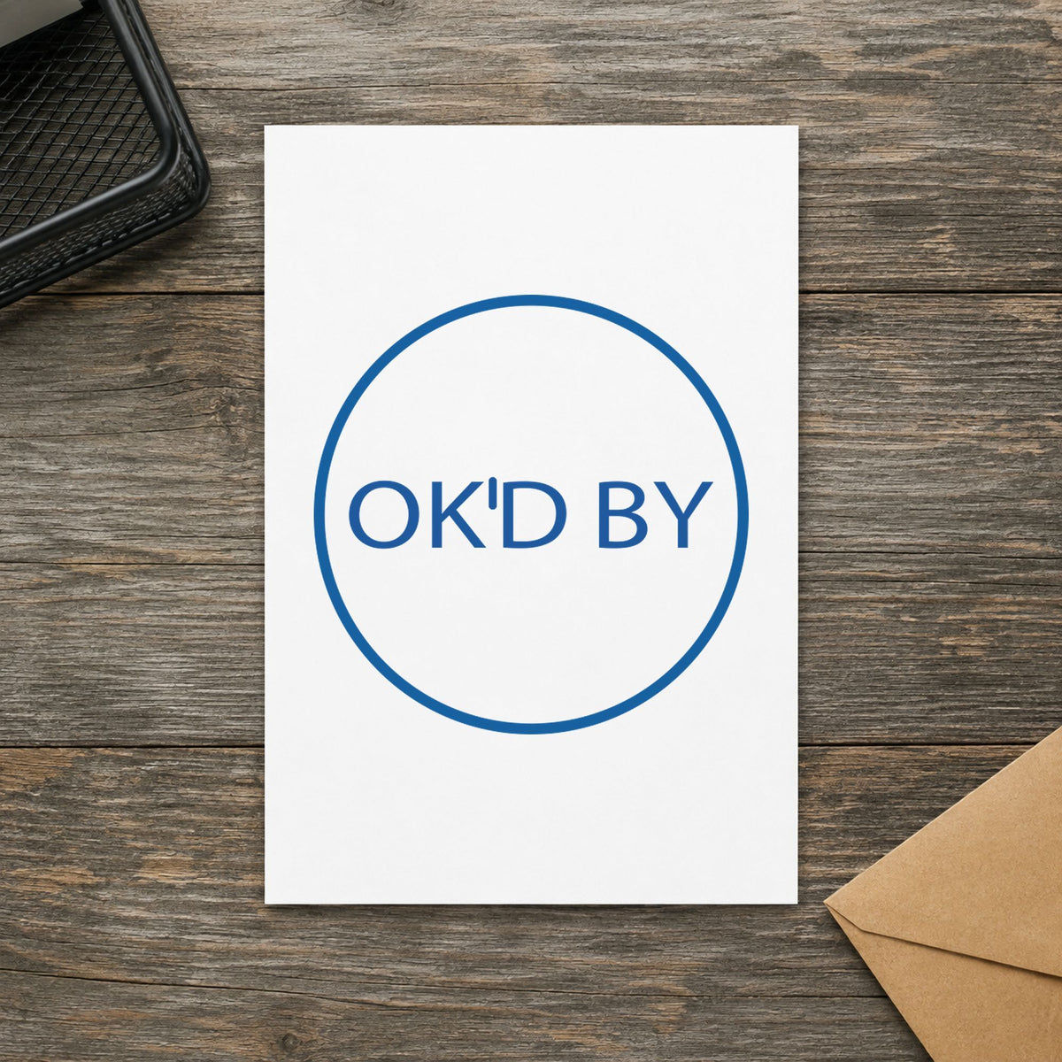 Pre-inked "OK'd by" stamp marking paperwork in an office setting