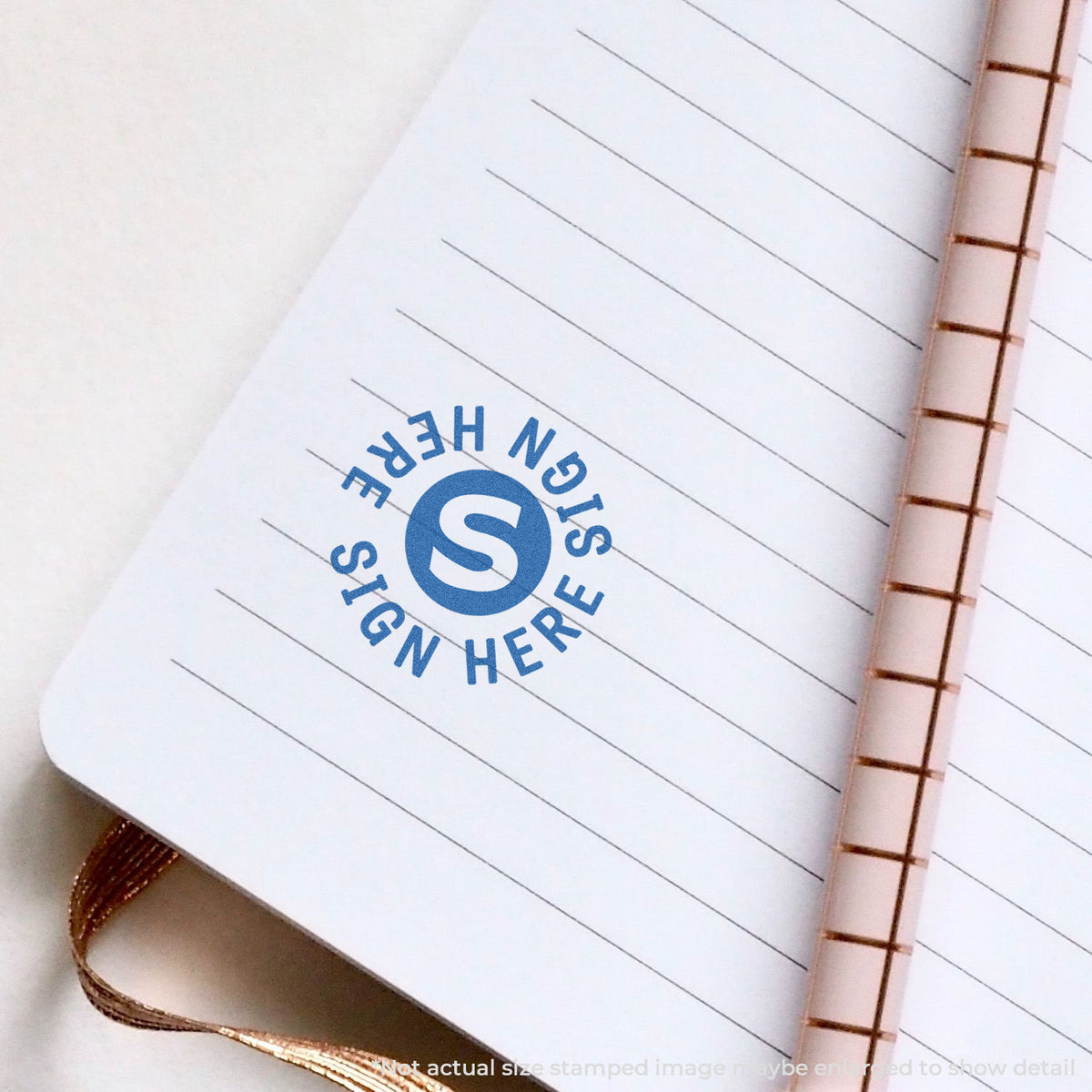 "Sign here" pre-inked imprint on a page, round shape at Approximately 5/8 in diameter