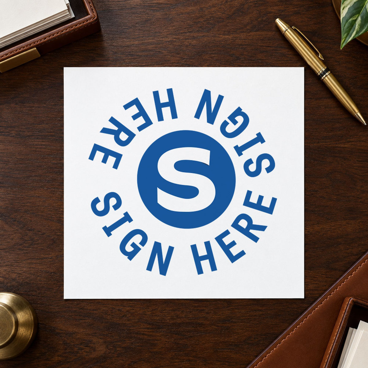 "Sign here" stamp pressed on paper, no separate ink pad needed