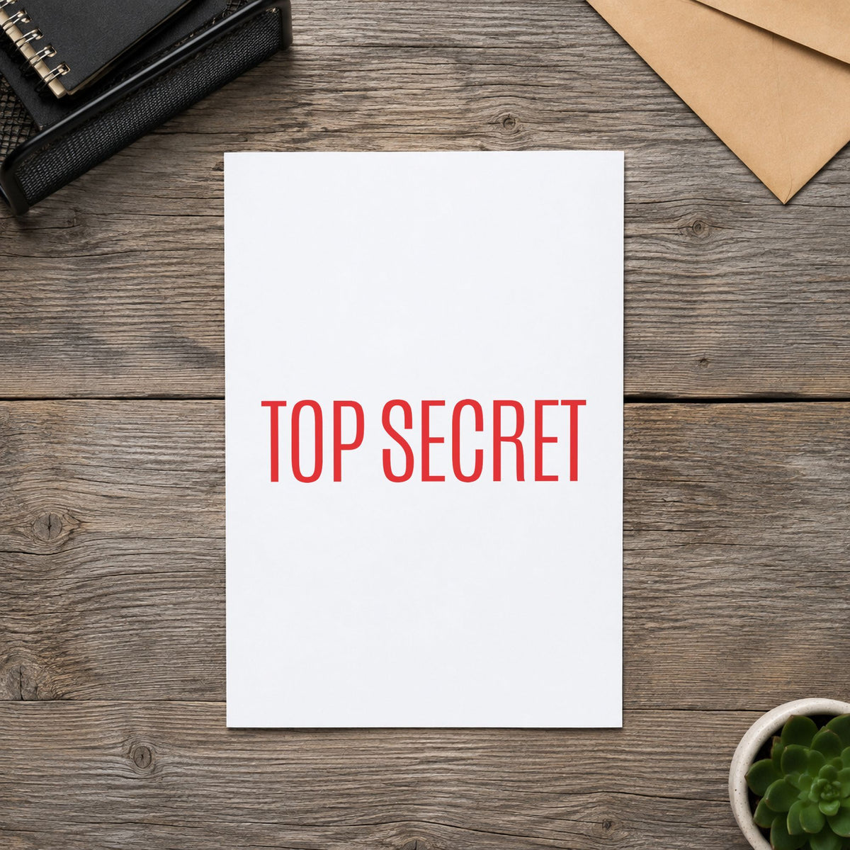"Top secret" Xstamper stamp in use on paper, Approximately 1/2 in tall x 1-5/8 in wide rectangle imprint