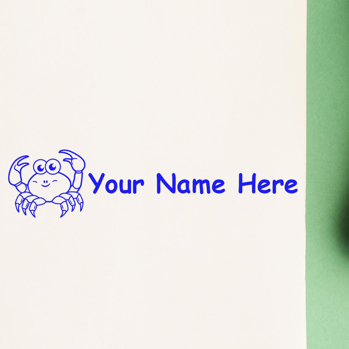 Blue crab stamp and seal with custom Your Name Here text in bright blue on white paper, beside a green edge.