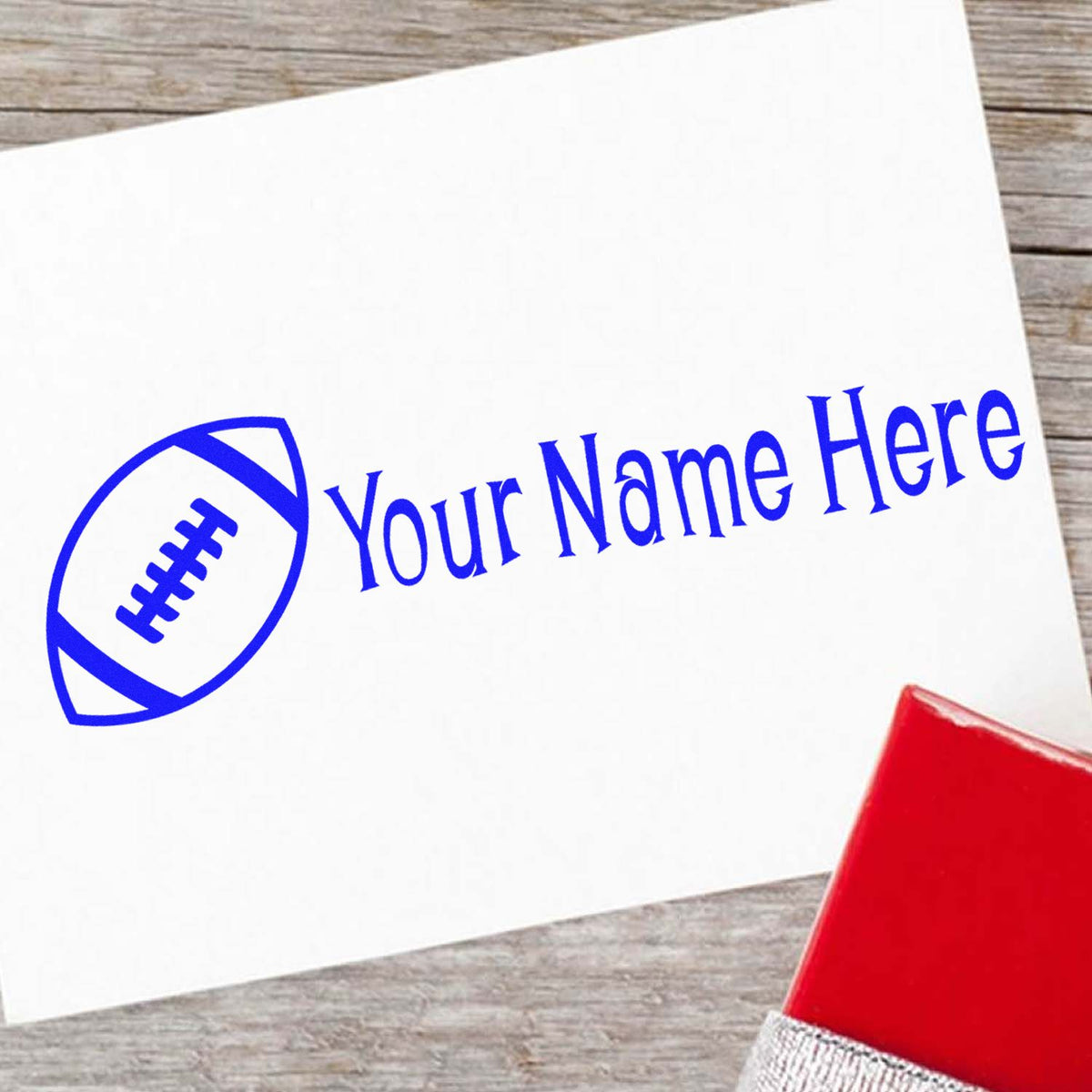 White card with blue custom football seal and Your Name Here text, plus a red stamp pad on a wood background.