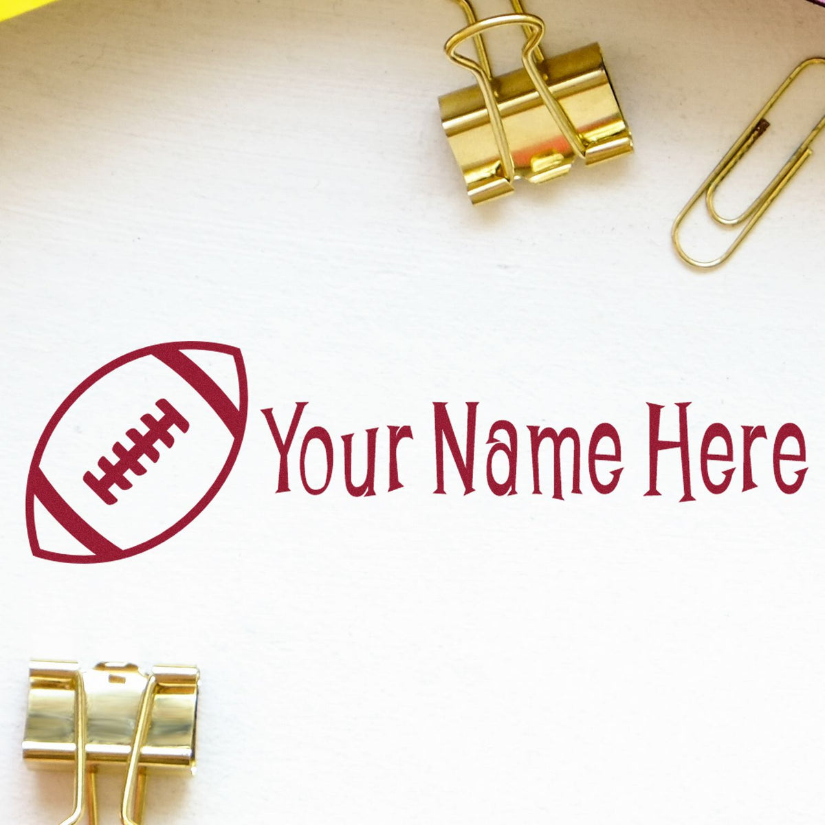 Red football logo with Your Name Here on white, framed by gold binder clips; custom stamp and seal branding.