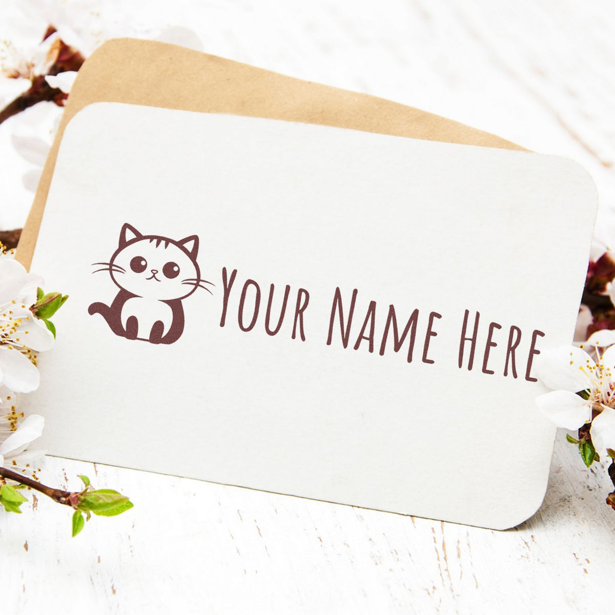 Custom brown cat stamp seal with Your Name Here on white card, framed by cherry blossoms.
