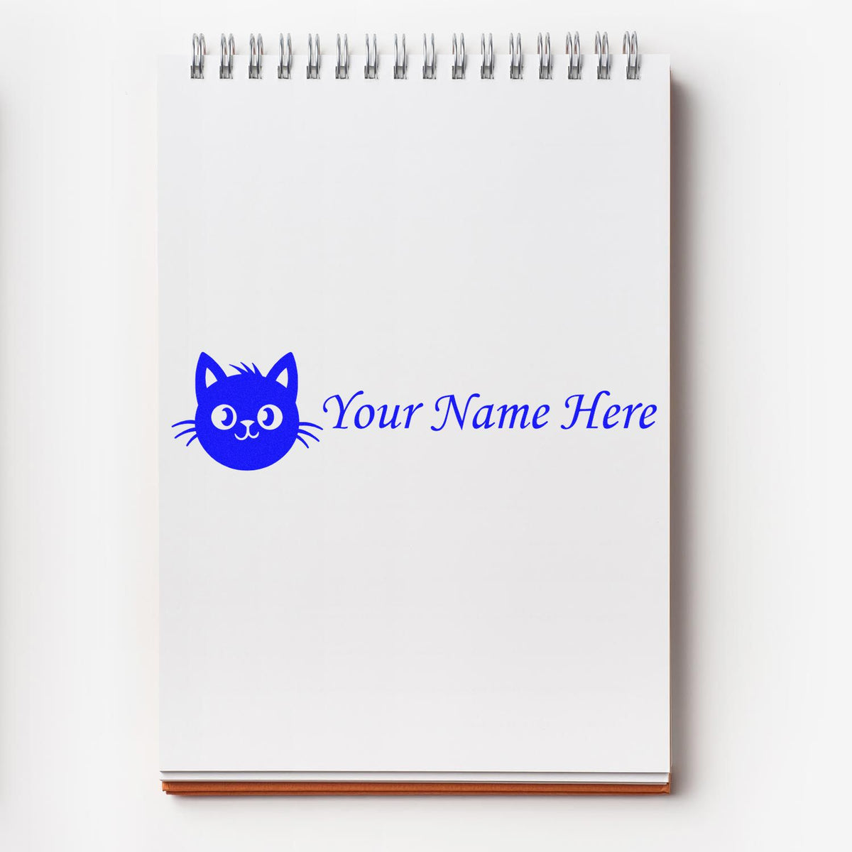 White spiral notepad with a blue custom stamp seal featuring a cat logo and Your Name Here text.