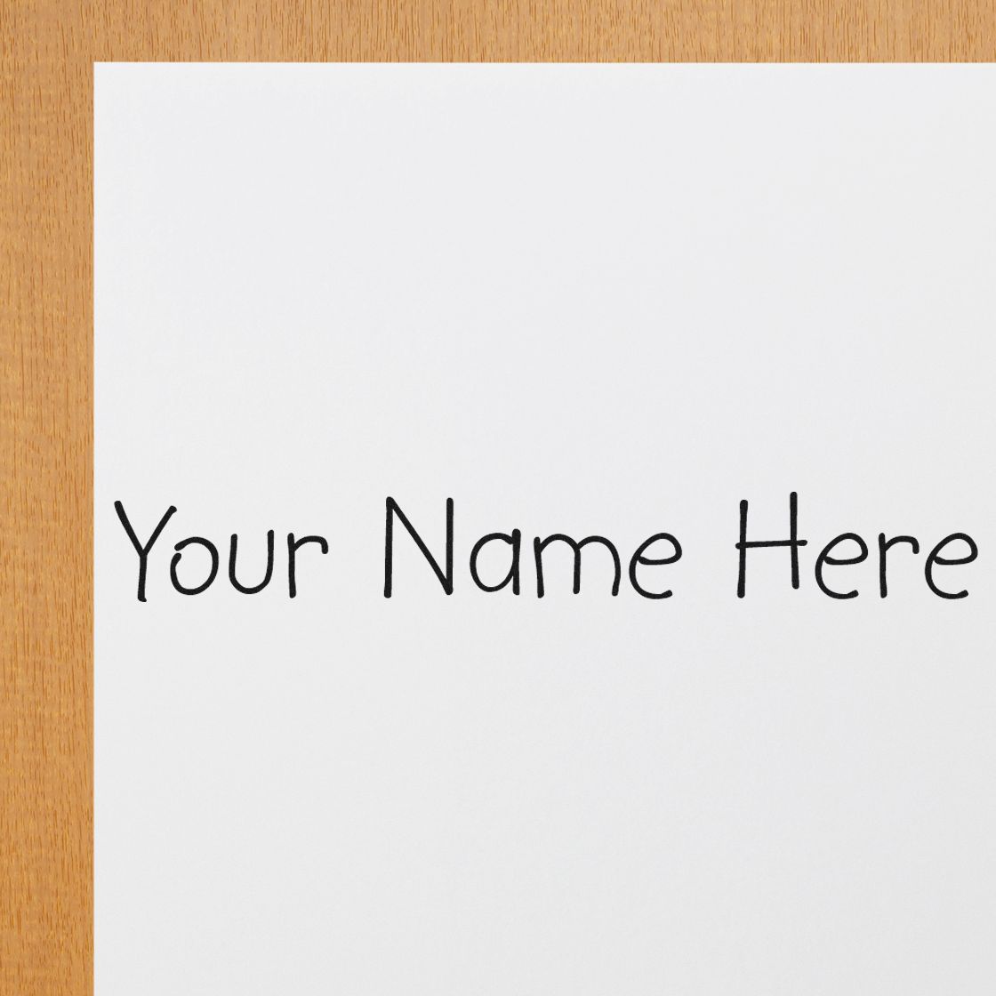 Custom stamp and seal mockup with black Your Name Here text on white paper over a wood background.