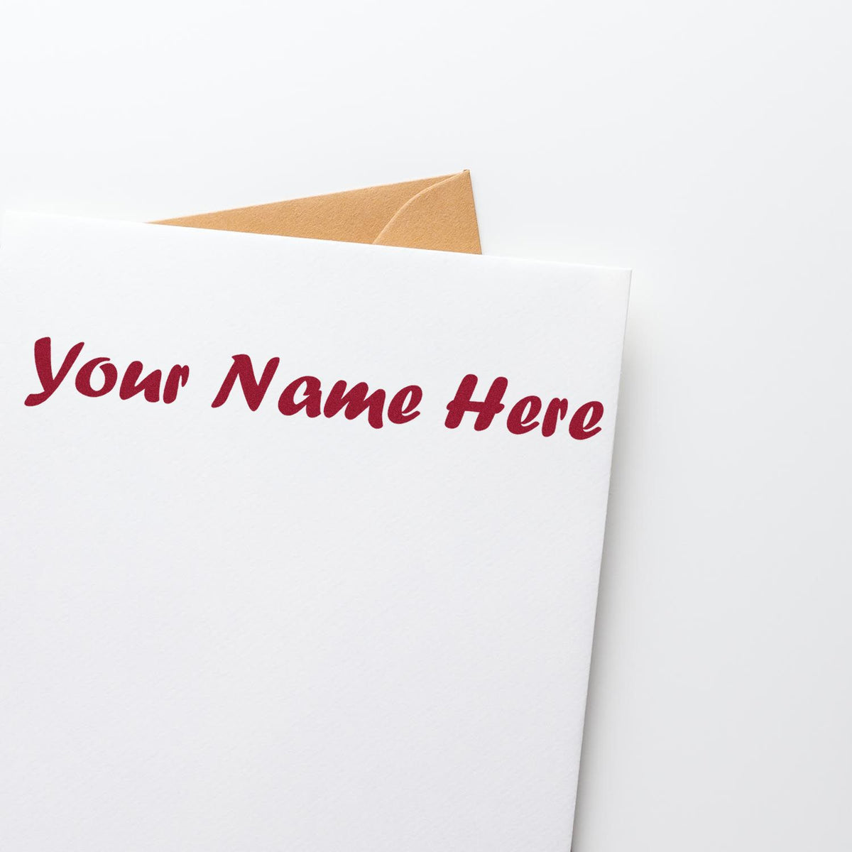 Burgundy custom stamp text on a white card with a tan envelope, showcasing personalized seal and stamp products