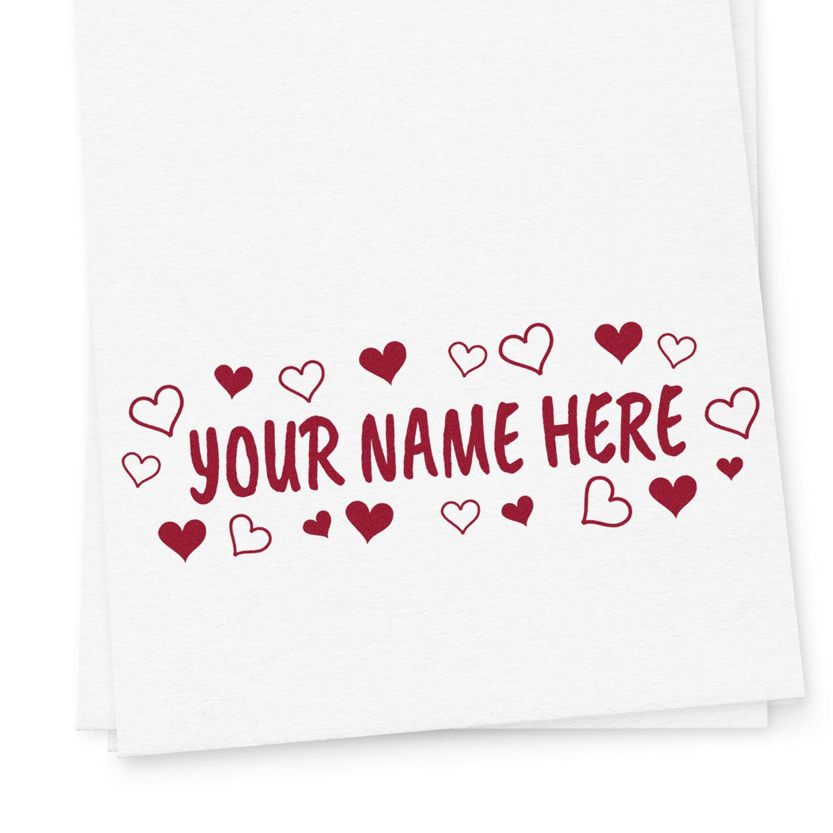 White paper with a red custom rubber stamp reading YOUR NAME HERE, framed by heart seal icons.