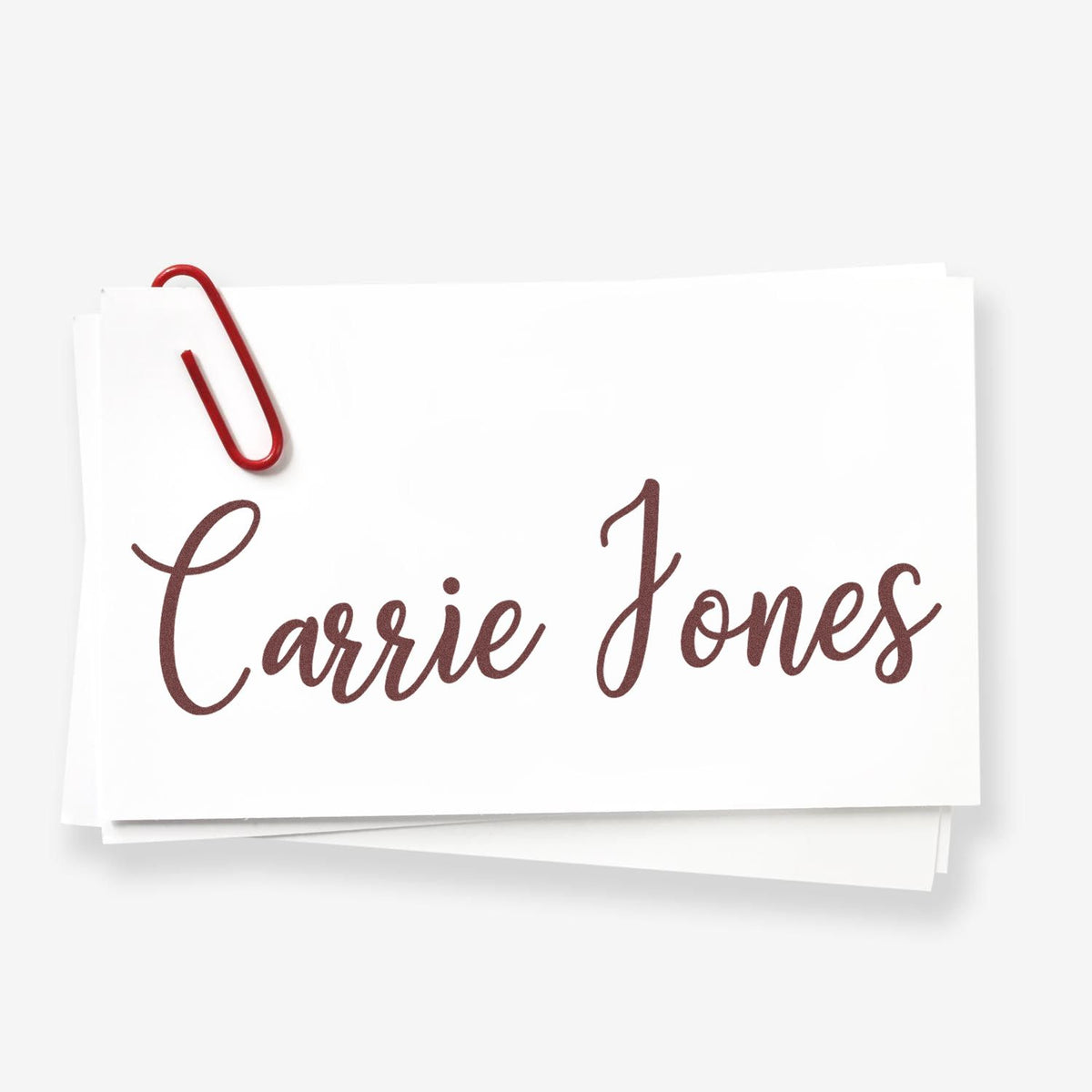 White stamp and seal cards with a red paperclip and brown cursive Carrie Jones text