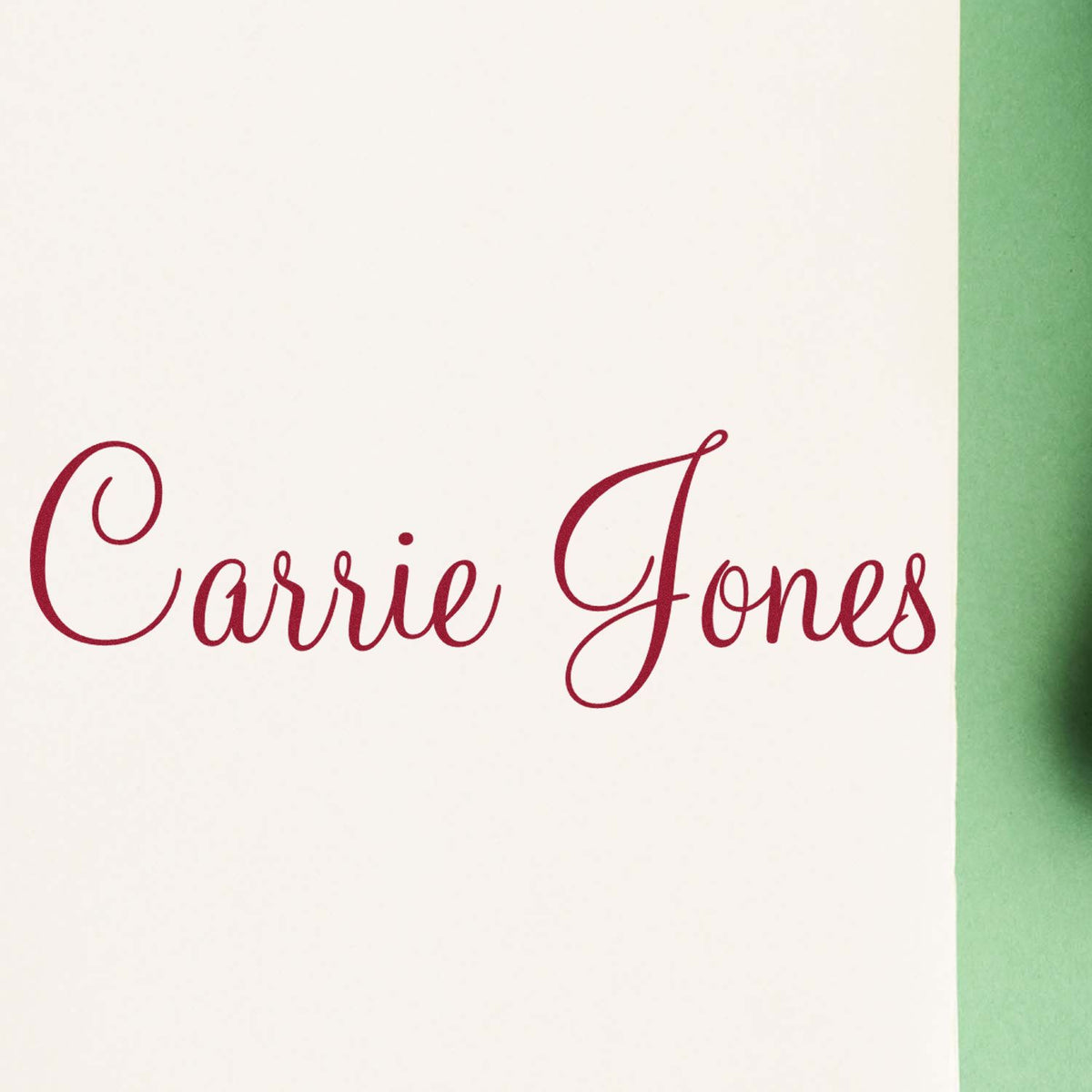 Custom burgundy script stamp and seal reading Carrie Jones on white card with green edge.