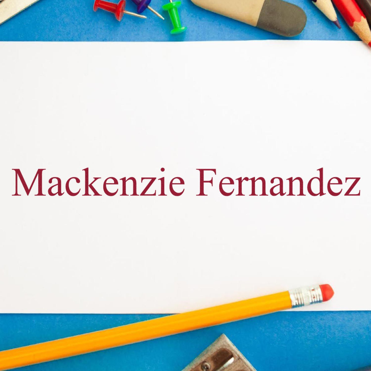 Personalized maroon name stamp and seal on white paper, framed by blue background, pencils, and pushpins.