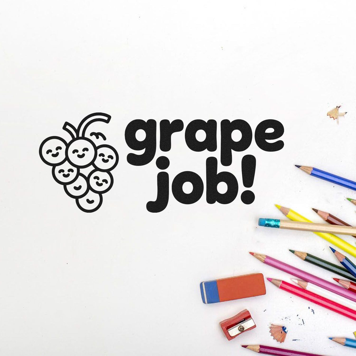 Black grape-themed grape job! stamp seal with smiling grape icon, surrounded by colored pencils, eraser and sharpener on white.