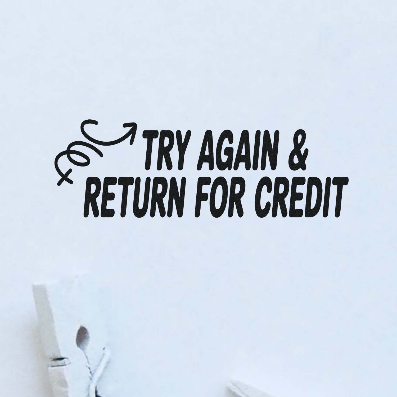 Black rubber stamp and seal reading Try Again & Return for Credit with a curved arrow on white paper.