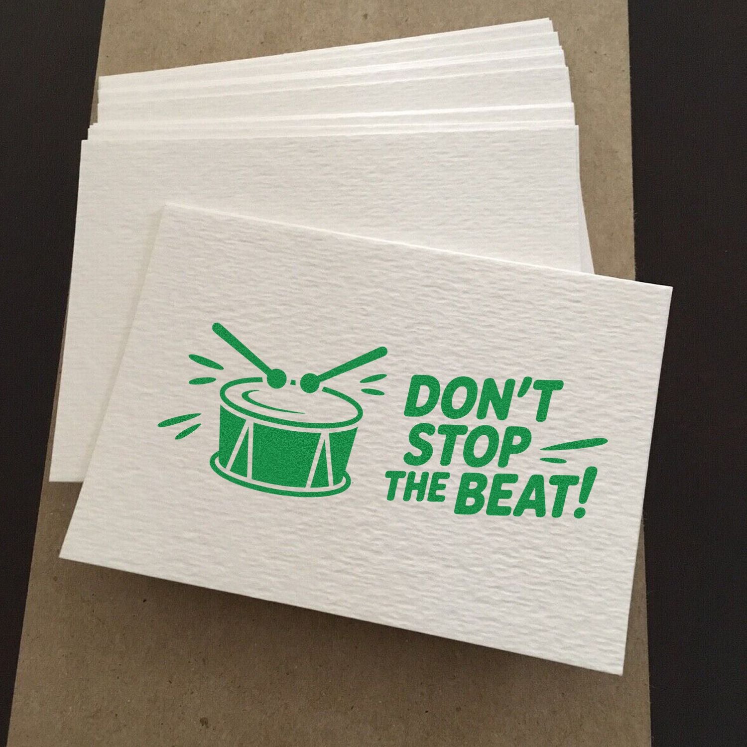 White textured stamp and seal paper sheets with green drum graphic and DONT STOP THE BEAT! text.