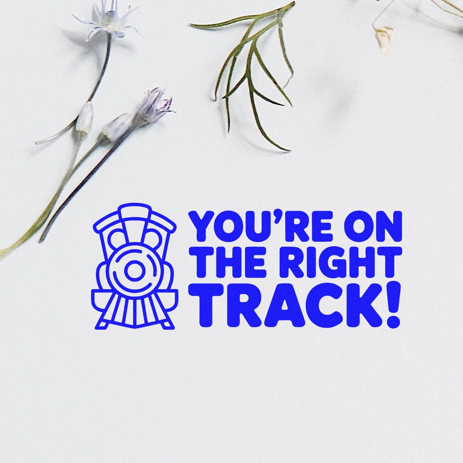 Blue stamp and seal design with steam train icon, Youre on the Right Track! text, and floral sprigs on white.