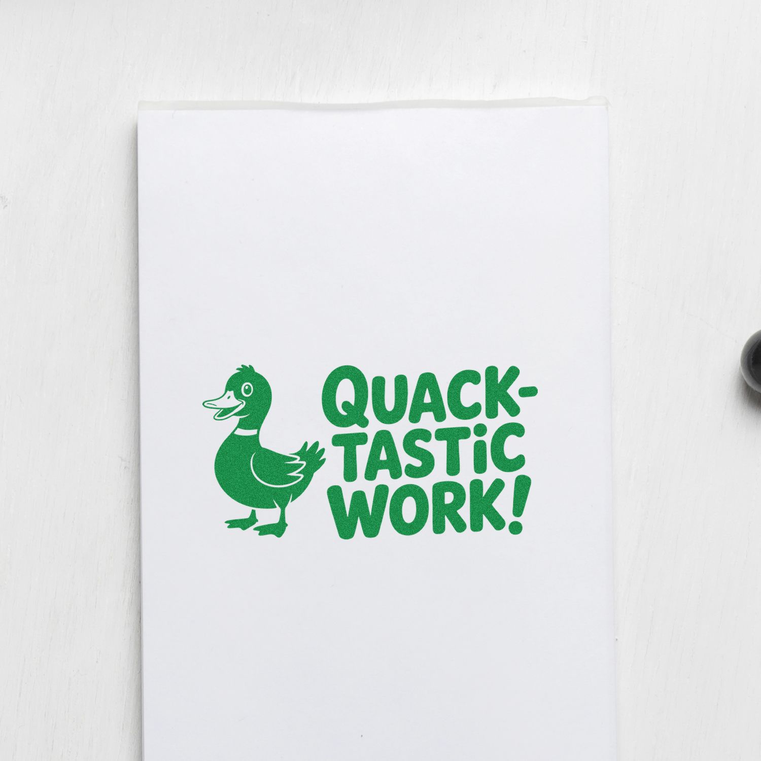 Green duck rubber stamp seal reading Quack-tastic Work! on white paper