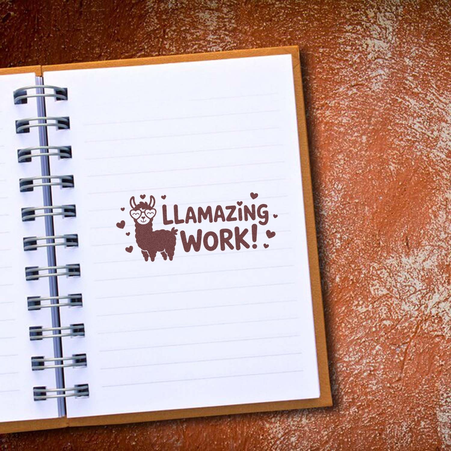 Brown llama stamp seal with hearts and Llamazing Work! on lined notebook paper.