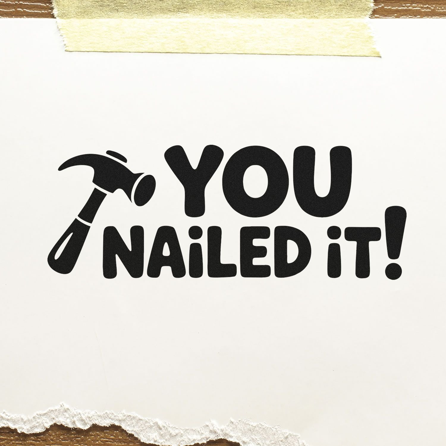 Black You Nailed It! stamp and seal with hammer icon on white paper, taped top and torn bottom edge.