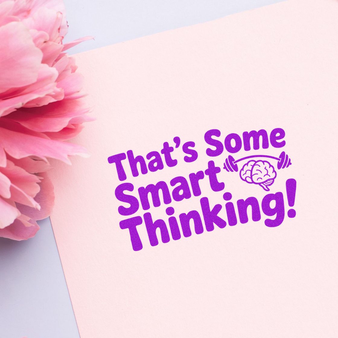 Purple stamp and seal reading Thats Some Smart Thinking! on pale pink paper with pink flowers and a brain icon.