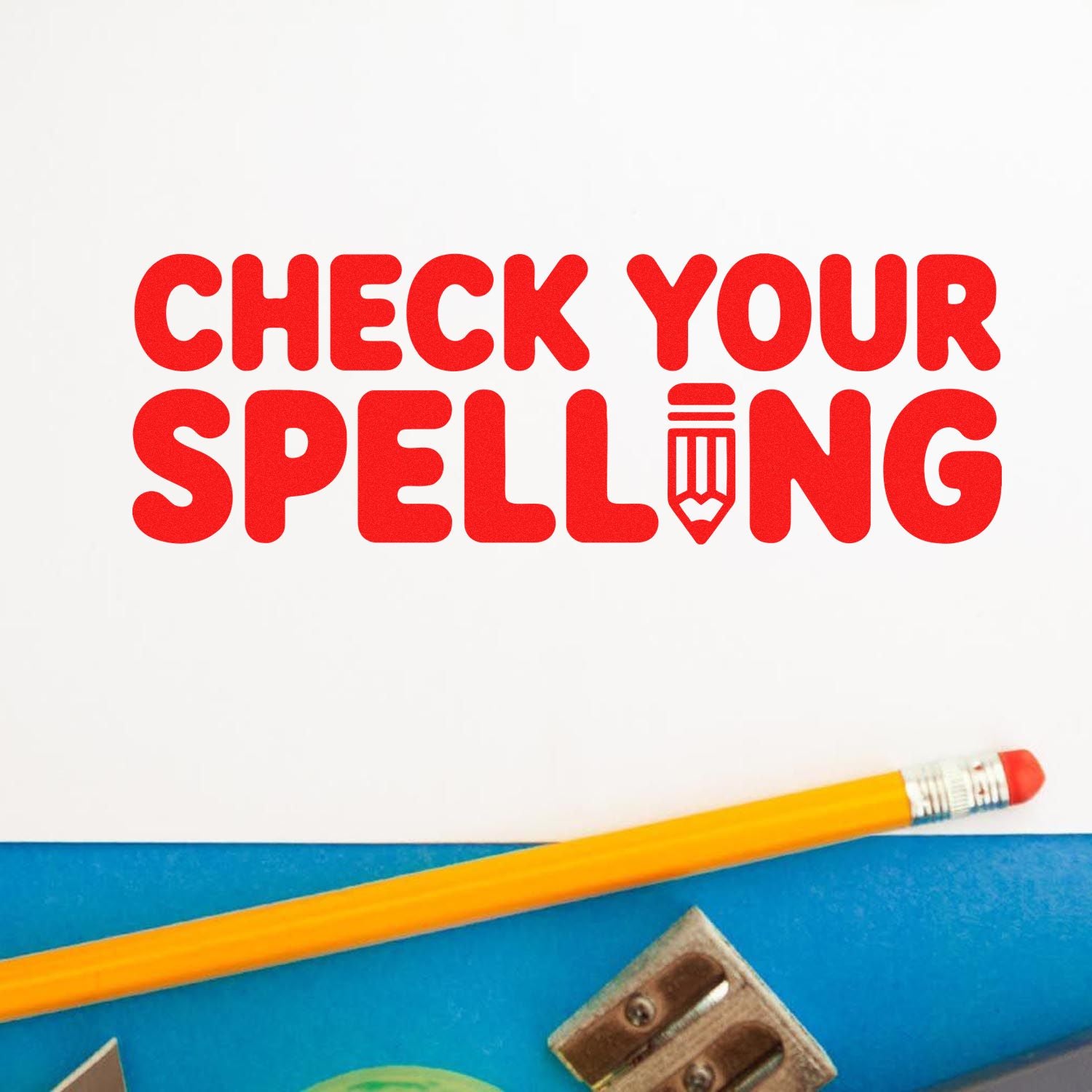 Red CHECK YOUR SPELLING stamp with pencil icon on white paper, beside a yellow pencil on blue background.